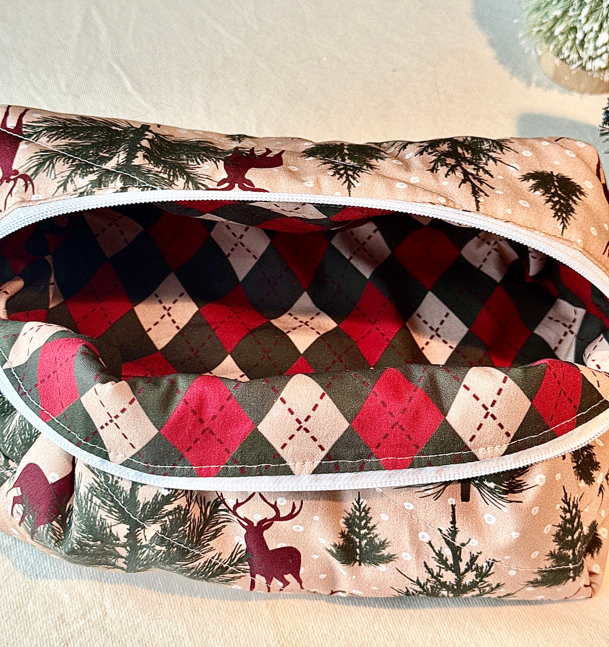 Close-up inside the open Winter Stag boxy bag showing its red, green, and cream diamond-patterned lining.