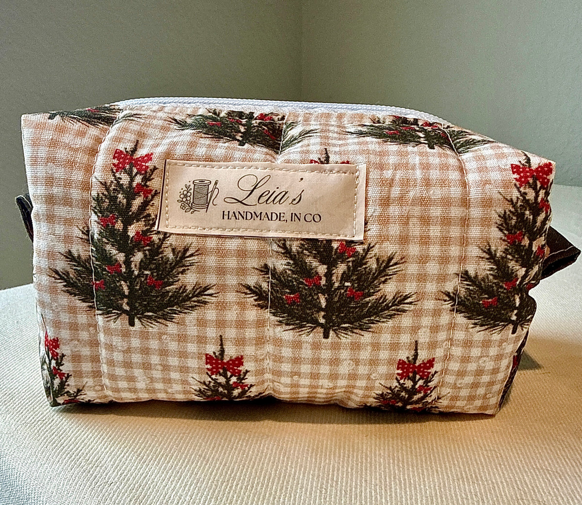 Front view of the small Winter Sprig quilted boxy bag with evergreen and red berry print and Leia’s handmade label
