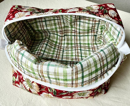 Close-up of the open Berry Blossom quilted boxy bag showing its empty green-and-cream plaid lining and white zipper.