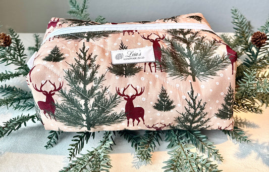Large handmade Winter Stag boxy bag with burgundy deer and evergreen trees on a cream background, photographed among greenery.