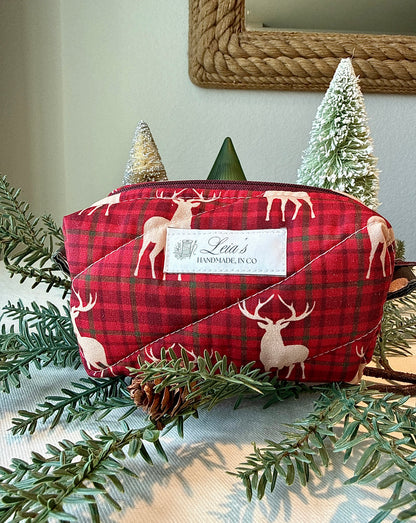 Small Highland Stag quilted boxy bag in red plaid with cream stag print and Leia’s handmade label, styled with winter greenery