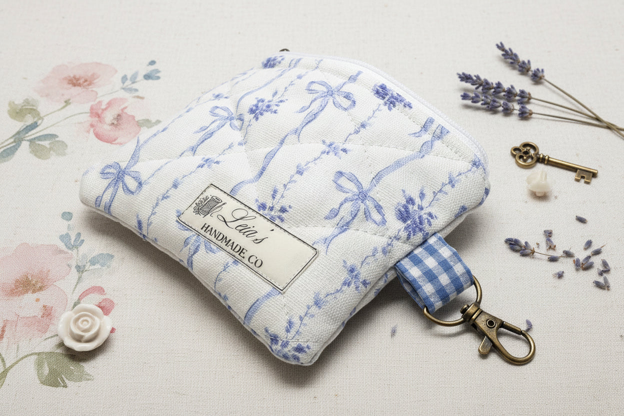 keychain wallet with blue bow and floral fabric, and a bronze clip