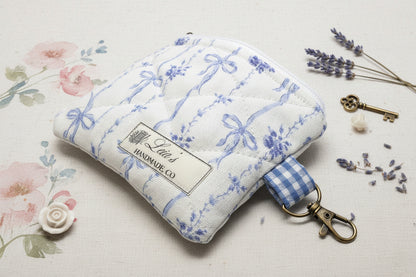 keychain wallet with blue bow and floral fabric, and a bronze clip