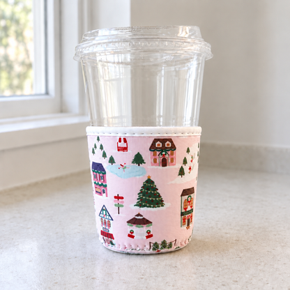 Christmas Village cup cozy on a neutral counter beside a window